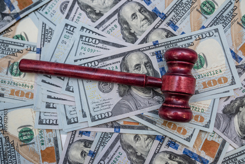 Judge Gavel Resting on One Hundred US Dollar Bills for Legal Compensation and Lawsuit Concept