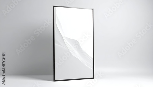 Modern presentation of an upright, rectangular picture frame leaning against a white studio wall with subtle, flowing, white art