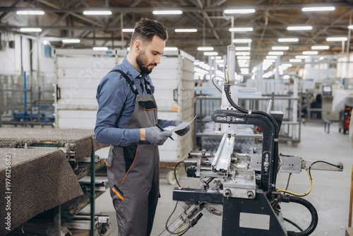 Factory worker inspecting aluminum profile manufacturing process