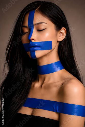 A woman with blue tape covering her mouth and body posing for a dramatic portrait