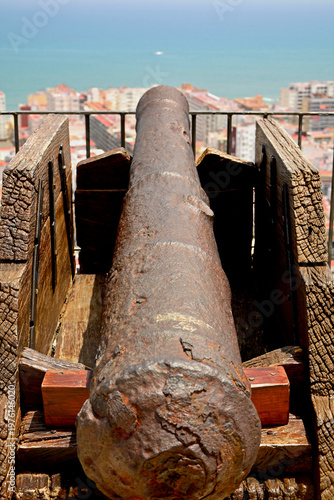 lufa zabytkowej armaty na tle krajobrazu i miasta, the barrel of an antique cannon against the background of the landscape and the city,