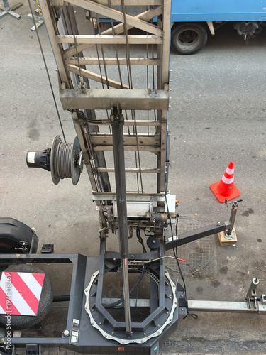 Billede på lærred From above, professional furniture hoist base assembly with hydraulic supports on urban asphalt