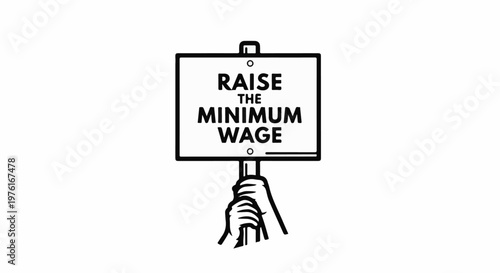 A hand holds a sign demanding a raise in the minimum wage
