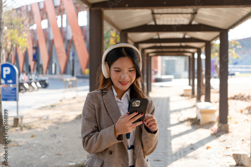 Asian businesswoman working on digital tablet with stylus outside modern building