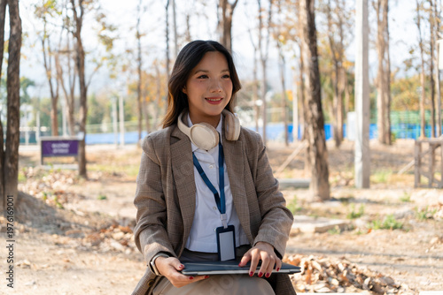 Asian businesswoman working on digital tablet with stylus outside modern building