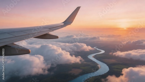 Airplane wing over river at sunset