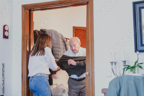 Foto Daughter helping elderly father getting dressed at home