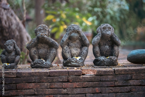 Fotografi Three wise monkeys stone statues in garden with symbolic meaning, See hear speak