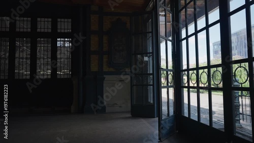 Blonde woman pulling a red suitcase arriving or departing from a journey. She is walking confidently through an elegant, dimly lit transit hub