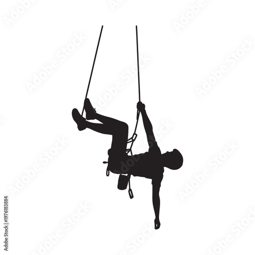 Silhouetted rock climber suspended in mid air actively scaling a wall