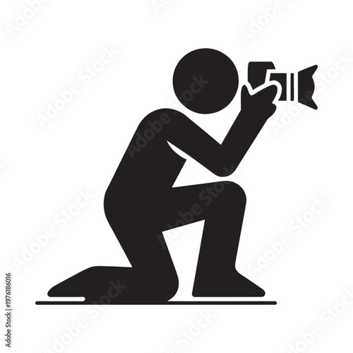 Simple black icon depicting a photographer kneeling and taking a picture