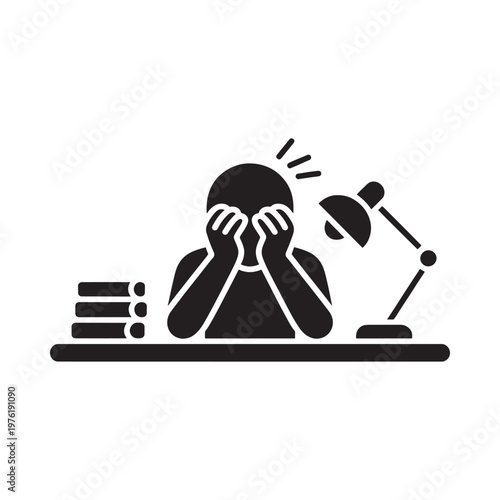 Frustrated student hides face while studying late at night with lamp