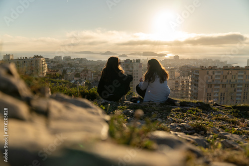Marseille,  deux jeunes femmes admirent le coucher de soleil sur la ville. Vue depuis Notre Dame de la Garde