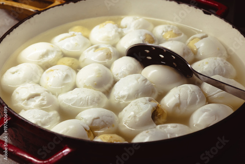 A pot filled with perfectly boiled eggs, floating in warm water, demonstrating a simple yet effective way to prepare healthy meals in an efficient manner.