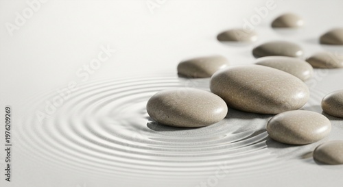 Smooth stones on white surface with water ripples and concentric circles