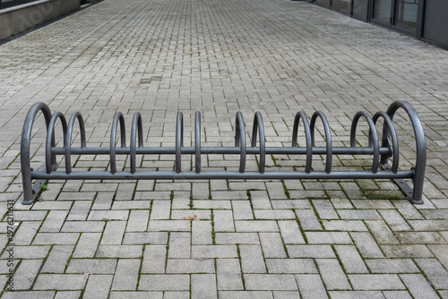 Wallpaper Mural Wide Empty Bicycle Parking In Courtyard With Long Row Of Steel Loops, Expansive Paving And Muted Sky, Shows Sustainable Mobility Infrastructure Awaiting Commuters, Clean Geometry And Civic Space Torontodigital.ca