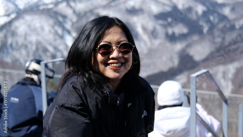 Cheerful Young Woman with Braces Enjoying Sunny Winter Mountain Landscape
