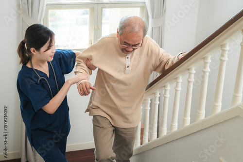 Fotografie Senior man receives support from caregiver while climbing stairs in nursing home