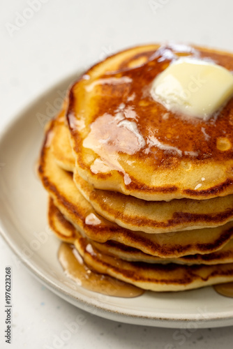 Stack of pancakes on a ceramic plate on a light surface 