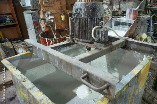 Industrial paint mixer machine in a workshop. Chemical processing and manufacturing of coating materials using heavy duty machinery