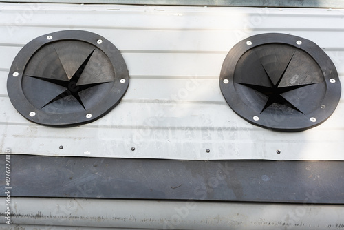 Wallpaper Mural Metal Star Vent On White Siding, Closeup Circular Grille With Exposed Bolts And Weathered Paint, Industrial Texture And Soft Shadow, Useful For Maintenance Inspection And Facility Documentation Torontodigital.ca