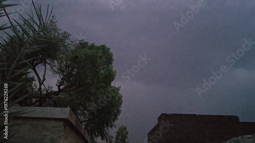 A dark scene featuring a lightening & thunder faintly illuminated object with a noticeable reflection and subtle highlights in the background