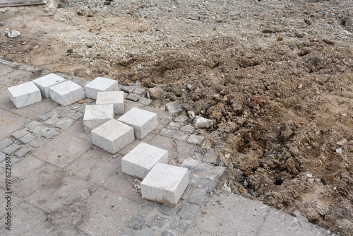 Wallpaper Mural Stacked Paving Stones Beside Dug Soil, Exposed Trench With Scattered Gravel And Dust, Uneven Pavement Edges, Loose Concrete Blocks Arranged For Manual Installation, Muted Overcast Light, Gritty Urban Torontodigital.ca
