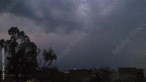 A dark scene featuring a lightening & thunder faintly illuminated object with a noticeable reflection and subtle highlights in the background