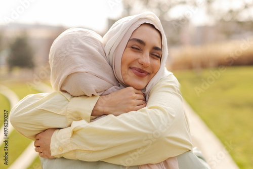 Canvastavla Two Muslim women in hijab embracing meeting in park outdoors