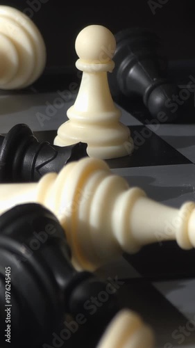 Last pawn standing: Macro shot of fallen chess pieces after battle