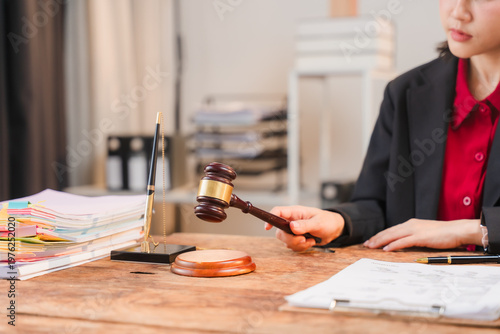 Photography Justice in Action: A legal professional, holding a gavel, poised to administer justice within the setting of a law office, embodies precision and the solemnity of legal proceedings