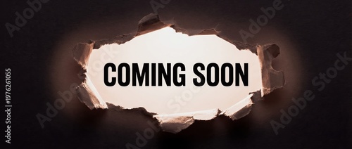 A dark background with a torn hole revealing a bright light and the words COMING SOON in bold black letters