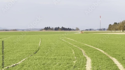 tractor harrowing agricultural field in spring