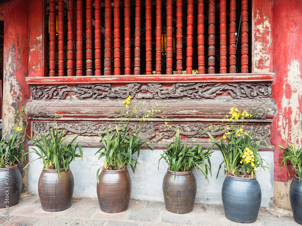 Fototapeta premium Traditional Vietnamese landmarks with intricate architecture, lush trees, and vibrant flowers. Symbolize cultural heritage and Vietnam tourism. Ideal for vacation, adventure, and cultural content