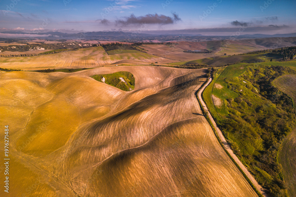 Fototapeta premium Rolling hills and winding road in Tuscan countryside, Asciano, Italy.