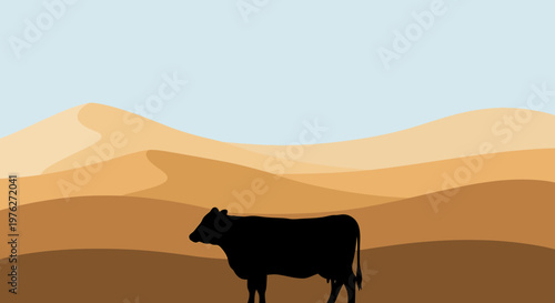 Silhouette of a cow in a desert landscape against a blue sky background