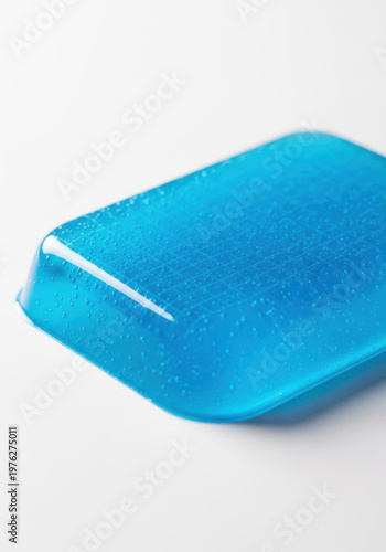 Blue cooling gel patch textured surface with soft studio light and water droplets conveying soothing relief