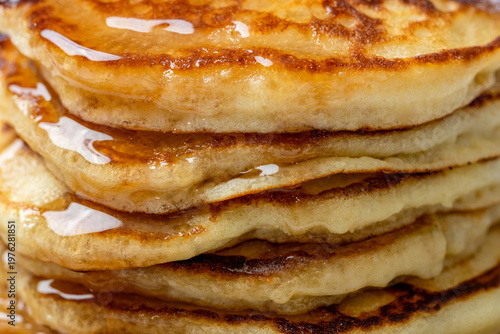 Close-up of a stack of pancakes on a ceramic plate on a light surface 