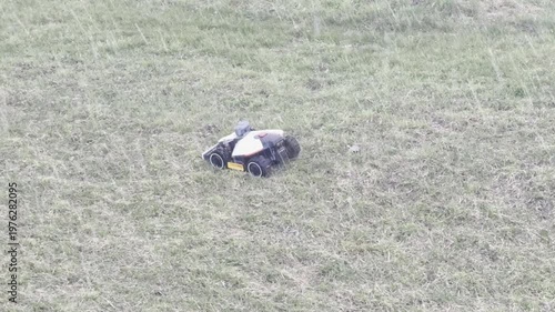 robotic lawnmower working in sleet shower