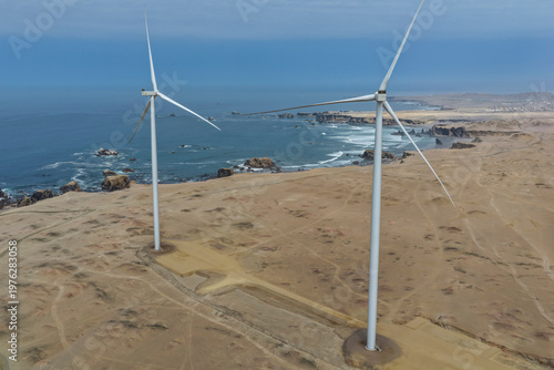 Aerial view of enormous wind turbines built facing the sea in strong wind currents