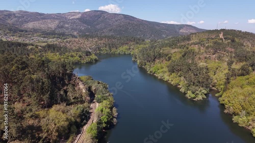 River reflecting a hotel and restaurant building surrounded by a forest in galicia, spain