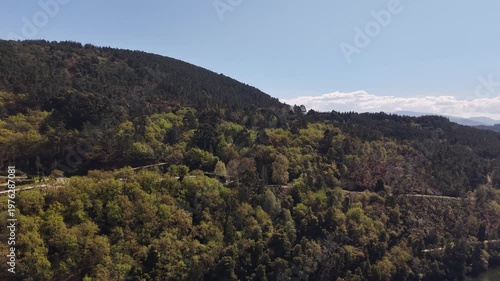 River reflecting a hotel and restaurant building surrounded by a forest in galicia, spain