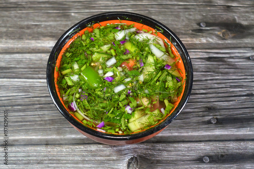 a bowl of green salad, with slices of fresh tomato, cucumber, onion, dill, parsley, lettuce, green pepper and leek, healthy green salad of fresh vegetables, healthy food diet