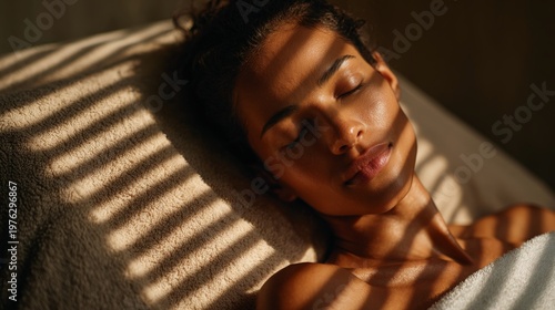 spa scene - close-up of a woman lying on a massage bed with closed eyes