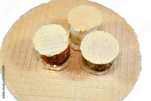 Various small, sweet treats, thin, crispy wafers sandwiching patties of sesame, peanuts or coconut and thin wafers, held together by honey or sugar, popular on Egyptian beach called Freska or Fresca