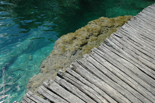 Bilde på lerret Close up of a rustic wooden log boardwalk built over a mossy tufa barrier in cle