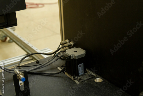 The image displays a close-up of a high-tech industrial or experimental apparatus, likely a component of a 3D printer or specialized imaging system. Technology