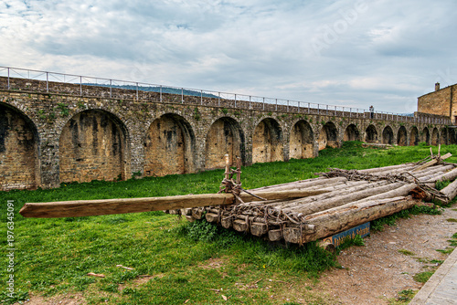 Ainsa Castle in the medieval village of Ainsa in Spain surrounded by stone walls with an elevated path leading to it.