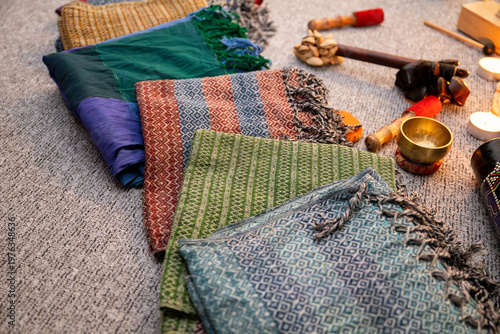 Rebozo massage and sound healing setup with Tibetan singing bowls, candles, yoga mats and traditional textiles, creating a calming wellness and holistic therapy atmosphere.
