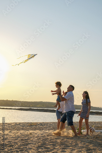 Bilde på lerret Happy family enjoying summer vacation, parents playing with children and dog on